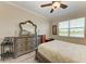 The main bedroom has lake views from the window, stylish dressers, bedside tables, and a comfortable bed at 12827 Lily Quartz Loop, Parrish, FL 34219
