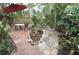 Charming backyard featuring a brick patio with dining set and lush tropical landscaping, creating a private outdoor retreat at 1308 63Rd Nw St, Bradenton, FL 34209