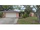 Charming single-story home showcasing a well-maintained front yard, attached two-car garage, and pink exterior paint at 1308 63Rd Nw St, Bradenton, FL 34209