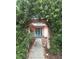 Inviting front entrance with a decorative archway, lush greenery, and a cozy sitting area at 1308 63Rd Nw St, Bradenton, FL 34209