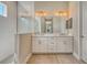 Bathroom with a double sink vanity, a large mirror, and tiled walk-in shower at 13908 Painted Loop, Parrish, FL 34219