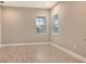 Bright, empty bedroom with wood-look tile floors, two windows, and neutral paint at 13908 Painted Loop, Parrish, FL 34219