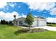 Well-maintained home featuring a manicured lawn, decorative trees, and a spacious two-car garage at 13908 Painted Loop, Parrish, FL 34219