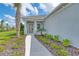 Charming covered entryway with a decorative palm tree and walkway leading to front door at 13908 Painted Loop, Parrish, FL 34219