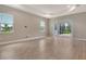 Neutral living room with large windows and a sliding glass door leading to the covered patio at 13908 Painted Loop, Parrish, FL 34219