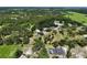 An aerial view of property featuring lush, green acreage, a house, outbuildings, and mature trees at 15780 Wilson Rd, Sarasota, FL 34240