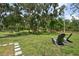Lush backyard featuring a mature tree, seating, and grass at 15780 Wilson Rd, Sarasota, FL 34240