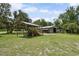 View of a traditional barn structure with tractor and implements parked under a shelter at 15780 Wilson Rd, Sarasota, FL 34240