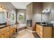 Bathroom featuring a corner soaking tub, dual vanities with granite countertops, and natural light at 15780 Wilson Rd, Sarasota, FL 34240