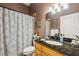 Bathroom featuring granite counters, tiled shower with patterned curtain, and an interior door at 15780 Wilson Rd, Sarasota, FL 34240