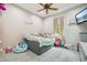 Cozy bedroom featuring a ceiling fan and a plush bed adorned with colorful stuffed animals at 15780 Wilson Rd, Sarasota, FL 34240