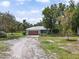 Charming home featuring a spacious driveway, lush landscaping, and mature trees at 15780 Wilson Rd, Sarasota, FL 34240