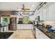 Bright kitchen with white cabinets, granite countertops, stainless steel appliances, and a large window overlooking the yard at 15780 Wilson Rd, Sarasota, FL 34240