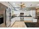 Well-lit kitchen showcasing stainless steel appliances, granite countertops, and ample white cabinetry at 15780 Wilson Rd, Sarasota, FL 34240