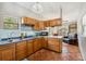 Charming kitchen featuring wood cabinets, stainless steel sink, and cozy breakfast bar with ample counter space at 15780 Wilson Rd, Sarasota, FL 34240