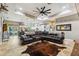 Expansive living room featuring travertine floors, tray ceilings, a large leather sectional, and an open concept layout at 15780 Wilson Rd, Sarasota, FL 34240