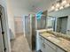 Well-lit bathroom with modern vanity, granite countertop, glass-enclosed shower, and a walk-in closet at 16087 Sunny Day Dr, Bradenton, FL 34211