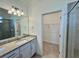 Bright bathroom showcases modern vanity, granite countertop, sleek shower, and convenient walk-in closet access at 16087 Sunny Day Dr, Bradenton, FL 34211