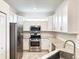 Bright, well-equipped kitchen featuring white cabinets, stainless steel appliances, and granite countertops at 16087 Sunny Day Dr, Bradenton, FL 34211
