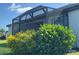 Screened-in patio surrounded by lush landscaping, perfect for outdoor relaxation at 16087 Sunny Day Dr, Bradenton, FL 34211