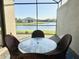 Enclosed patio seating area with scenic lake view, perfect for relaxing and enjoying the outdoors at 16087 Sunny Day Dr, Bradenton, FL 34211