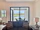 Relaxing patio view with serene lake backdrop, seamlessly accessible from the cozy interior living space at 16087 Sunny Day Dr, Bradenton, FL 34211