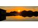 A beautiful sunset view over houses reflecting off the pond creates a relaxing and picturesque community ambiance at 16087 Sunny Day Dr, Bradenton, FL 34211