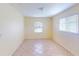 A clean and empty bedroom shows neutral tile floors and two windows at 1707 24Th E St, Palmetto, FL 34221