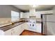 Well-lit kitchen features white cabinets, stainless steel refrigerator, and a double sink at 1707 24Th E St, Palmetto, FL 34221