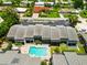Overhead view of townhomes featuring a refreshing community pool, screened lanais, and lush landscaping at 1753 Dawn St # 305, Sarasota, FL 34231