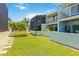 The spacious backyard features lush green grass, tropical plants, and a path to the pool at 1753 Dawn St # 305, Sarasota, FL 34231
