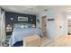 Bedroom featuring blue accents, light wood flooring, and adjacent hallway and bathroom at 1753 Dawn St # 305, Sarasota, FL 34231