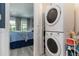 Laundry room leads to bedroom with light wood flooring and stacked washer and dryer at 1753 Dawn St # 305, Sarasota, FL 34231