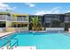 A refreshing community pool surrounded by residences featuring balconies and lush tropical landscaping at 1753 Dawn St # 305, Sarasota, FL 34231