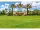 Del Webb Lakewood Ranch entrance sign with palm trees and lush green lawn on a sunny day at 17648 Northwood Pl, Lakewood Ranch, FL 34202