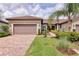 Charming single-story home featuring a tile roof, two-car garage, and lush landscaping at 17648 Northwood Pl, Lakewood Ranch, FL 34202