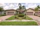 Charming home with a paved driveway, two-car garage, and lush landscaping at 17648 Northwood Pl, Lakewood Ranch, FL 34202