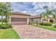 Well-maintained home with brick driveway, lush landscaping, and two-car garage provides curb appeal at 17648 Northwood Pl, Lakewood Ranch, FL 34202