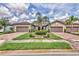 Well-maintained exterior featuring lush green landscaping, a paved driveway, and two-car garage at 17648 Northwood Pl, Lakewood Ranch, FL 34202