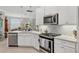 Modern kitchen with stainless steel appliances, sleek countertops, and bright white cabinetry at 17648 Northwood Pl, Lakewood Ranch, FL 34202