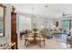 Elegant living and dining area with a glass table, chandelier, and shuttered windows at 17648 Northwood Pl, Lakewood Ranch, FL 34202