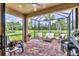 Screened-in patio with brick flooring and outdoor seating overlooking lush landscaping at 17648 Northwood Pl, Lakewood Ranch, FL 34202