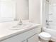 This bathroom features a white vanity, a single sink, modern fixtures, and a shower-tub combo with a bright, clean aesthetic at 1766 Cobb Trl, Parrish, FL 34219