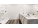 This bathroom features a double sink vanity, modern fixtures, and a walk-in shower with a clean and bright aesthetic at 1766 Cobb Trl, Parrish, FL 34219