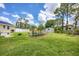 Large backyard with well-maintained lawn, a shed, lush grass, and a charming landscaping feature at 1778 N Salford Blvd, North Port, FL 34286