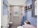 Updated bathroom features accessible shower, grab bars, gray vanity with sink and a blue decorative shower curtain at 1778 N Salford Blvd, North Port, FL 34286