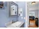 Updated bathroom with a gray vanity and mirror cabinet featuring a white vessel sink and modern faucet at 1778 N Salford Blvd, North Port, FL 34286