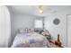 Bright bedroom with ceiling fan, a cozy quilt, throw pillows, and natural lighting from a nearby window at 1778 N Salford Blvd, North Port, FL 34286