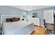 Inviting bedroom with light blue walls, a ceiling fan, wood floors, and a bright, airy feel at 1778 N Salford Blvd, North Port, FL 34286