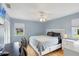 Comfortable bedroom features natural light from two windows, wood floors, and a TV screen at 1778 N Salford Blvd, North Port, FL 34286